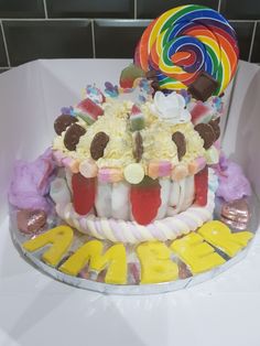 a birthday cake decorated with candy and lollipops