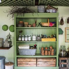 a green shelf filled with lots of pots and pans