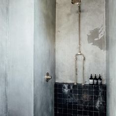 a black and white tiled bathroom with a shower head