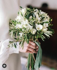 a person holding a bouquet of white flowers