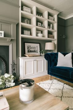 a living room filled with furniture and a fire place in front of a book shelf