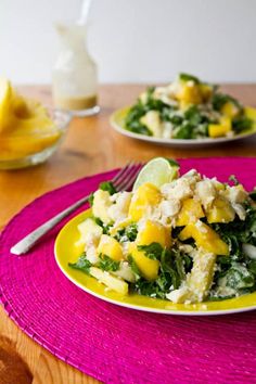 two plates with food on them sitting on a table next to lemons and water