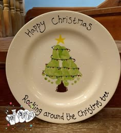 a white plate with a christmas tree painted on it and words written across the rim