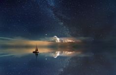 a boat floating on top of a body of water under a sky filled with stars