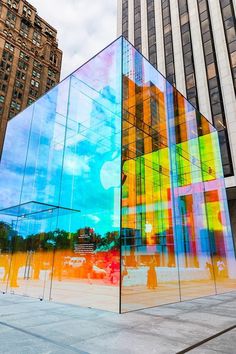 an apple store is shown in front of tall buildings with glass panels on the sides