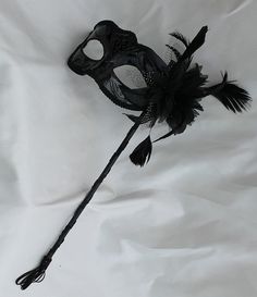 Stunning Black Masquerade Mask on a Stick with a flower made of black fabric petals, feathers and black and white organza $18.15  Handmade, Plastic, wood, paint with a tassel  Depth of Mask is 3”  Arrives 10-18 days later - Ships from the UK Adjustable Black Masquerade Mask For Carnival, Black Adjustable Masquerade Mask For Carnival, Black Adjustable Masquerade Mask, Black Adjustable Masquerade Mask For Party, Adjustable Black Masquerade Mask For Parties, Elegant Black Masks And Prosthetics For Theater, Gothic Black Eye Masquerade Mask, Black Gothic Eye Mask For Masquerade, Adjustable Black Masks And Prosthetics For Carnival