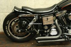 a black motorcycle parked on top of a wooden floor