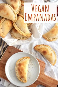 vegan empanadas on a white plate with a wooden cutting board in the background