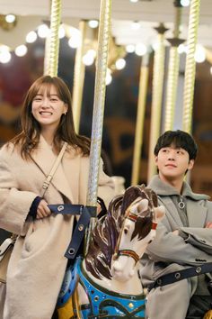 two people standing next to each other on a merry go round