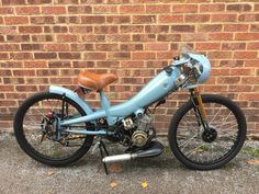 a blue motorcycle parked next to a brick wall