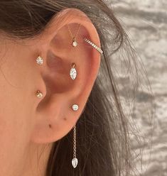 a close up of a person with ear piercings on their ears and behind the ear