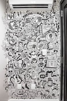 a bathroom with black and white doodles on the wall next to an air conditioner