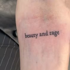 a person with a tattoo saying beauty and rage