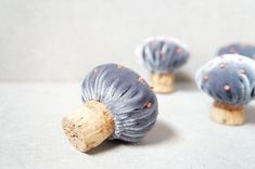 three small blue mushrooms sitting on top of a table