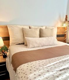 a bed with white and brown sheets in a bedroom