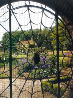 a circular window with an iron design in the center and purple flowers on the other side