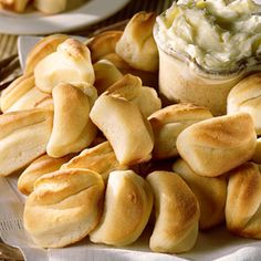 a plate full of bread rolls and a cup of dip