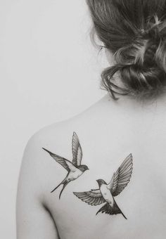 the back of a woman's shoulder with two hummingbirds on her left side