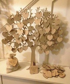 a white table topped with lots of wooden heart shaped trees and hearts hanging from them