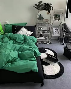 a bed with green sheets and pillows in a bedroom next to a black rug on the floor