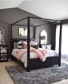 a bedroom with gray walls and white bedding, pink fur rugs on the floor