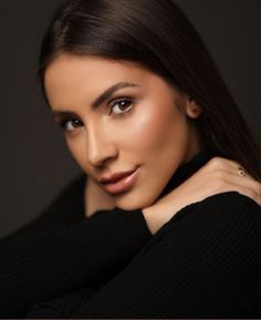 a woman is posing for a photo with her hand on her shoulder and looking at the camera