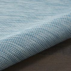 a close up view of a blue fabric on a wooden table with wood flooring