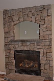 a living room with a fire place in the middle and a mirror on the wall