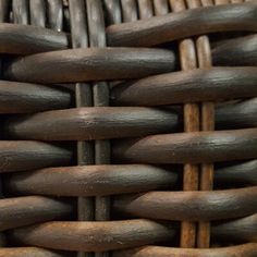 a close up view of an old woven basket with wood handles and metal rings on it