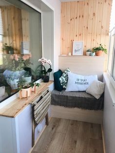 a small room with wood paneling and plants on the window sill