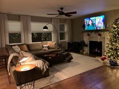 a living room filled with furniture and a christmas tree in front of a flat screen tv