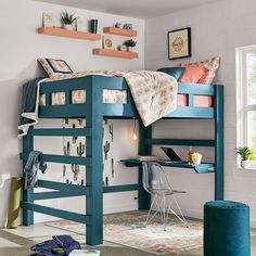 a blue bunk bed sitting in a bedroom next to a desk and chair on top of a rug