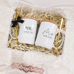 two personalized coffee mugs in a gift box with gold spoons and ribbon