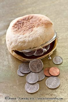 a sandwich sitting on top of a table next to some coins