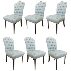 set of six upholstered dining chairs with wood legs and tufted backrests