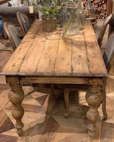 a wooden table with chairs and vases on it