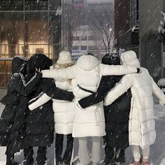 several people are huddled together in the snow on a city street during a winter storm