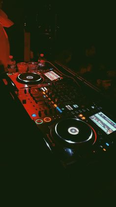 a dj mixing music in the dark with his turntables