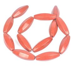 an orange beaded bracelet with oval shaped beads on white background and clipping to the side