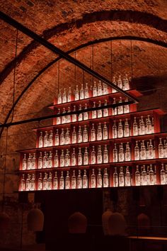 many glass bottles are stacked on top of each other in a room with exposed ceilings