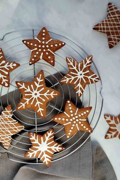 some cookies are on a cooling rack and decorated with snowflakes in the shape of stars