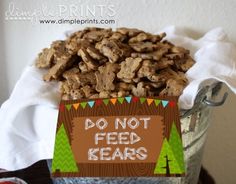 a bucket filled with lots of food next to a sign that says do not feed keats