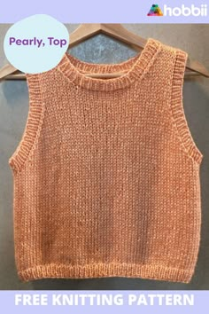 an orange knitted sweater hanging on a wooden hanger with the text, free knitting pattern