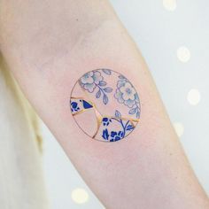 a woman's arm with a blue and white flowered design on it