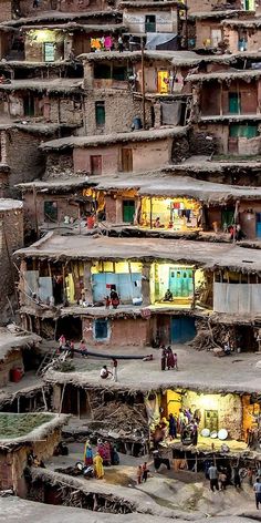 a group of people standing in front of some houses with no roofs on top of them