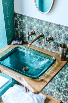 a blue sink in a bathroom under a mirror