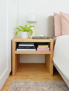 a nightstand with books and a plant on it