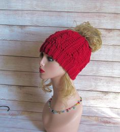 Maroon crocheted messy bun hat.  This fun ponytail hat features a cable pattern design. Crocheted using Red Heart Super Saver in Maroon colorway.   Relaxed circumference is 17" stretched is 21". Mannequin and beaded necklace not included in sale. Crochet Bun Hat, Fun Ponytails, Messy Bun Ponytail, Messy Bun Hat Crochet, Crochet Messy Bun, Bun Ponytail, Bun Beanie, Messy Bun Beanie, Ponytail Beanie