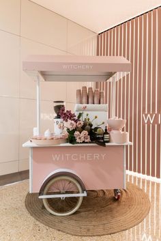 an ice cream cart with flowers on the front and shelves above it that says witchry