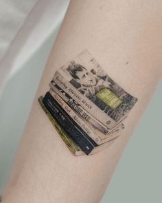 a person with a tattoo on their arm has books in the shape of a book